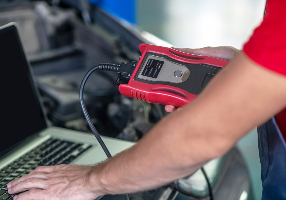 Male hands conducting car diagnostics using computer