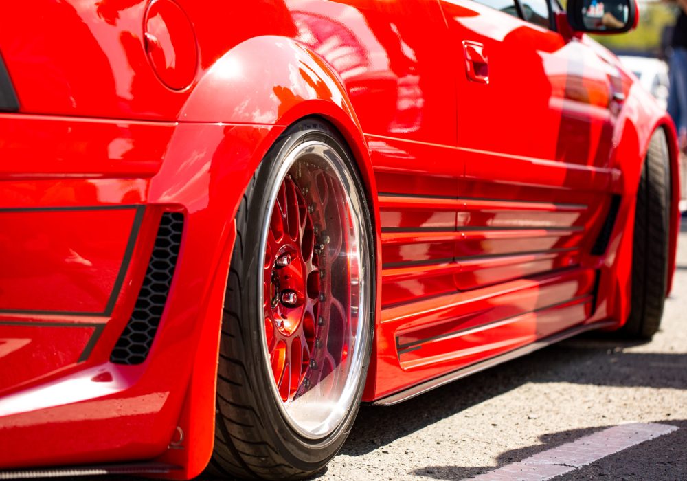 Red sports tuned car rear view of the wheel, close-up .